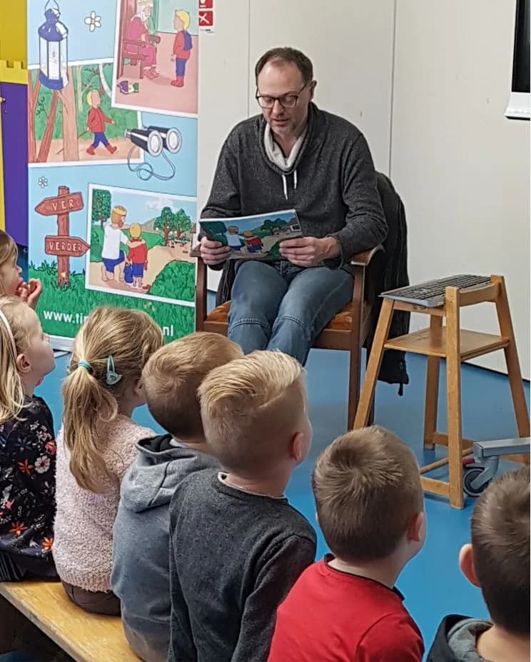 Jeroen Struik leest voor aan een groep kinderen